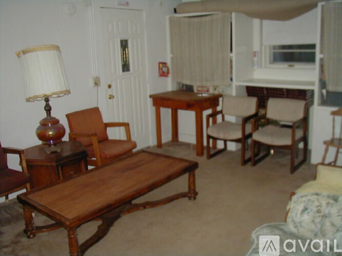 A living room with a couch, chairs, and a coffee table.