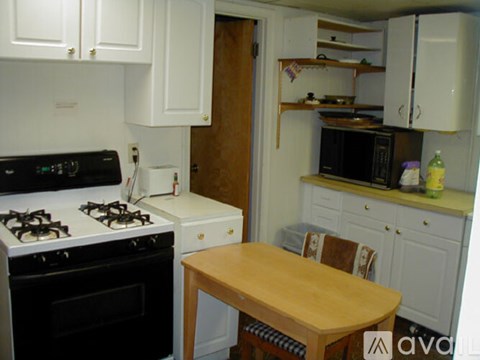 A kitchen with a stove, oven, and table.