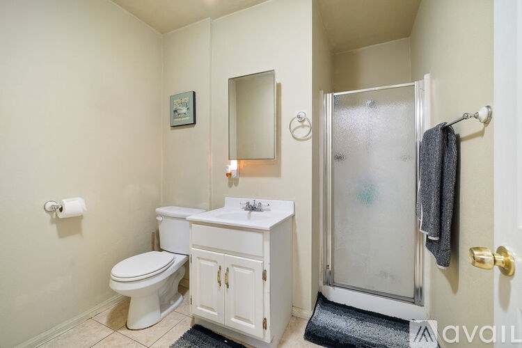 A bathroom with a toilet, sink, and shower.