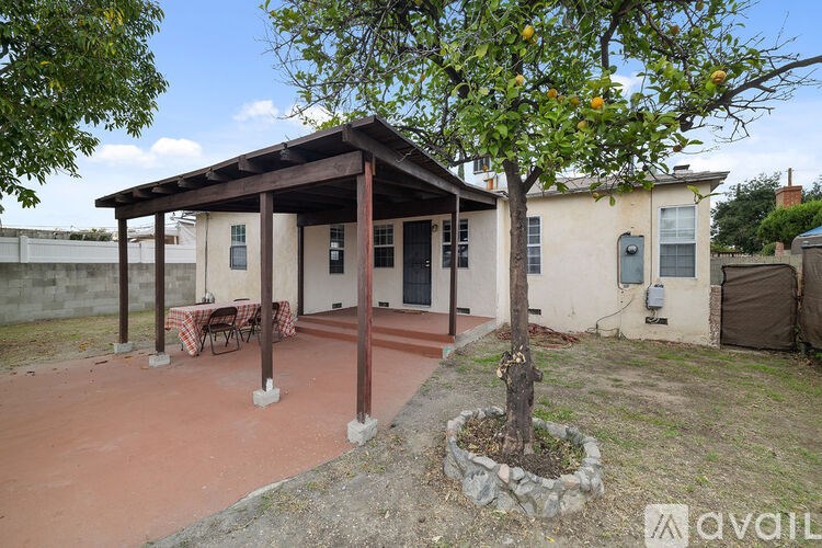 A house with a patio and a tree in front of it.