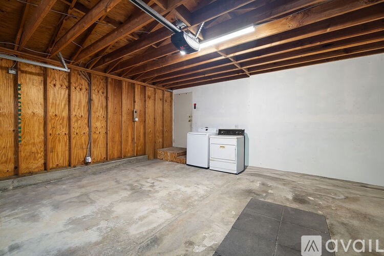 A room with wooden walls and a white fridge.