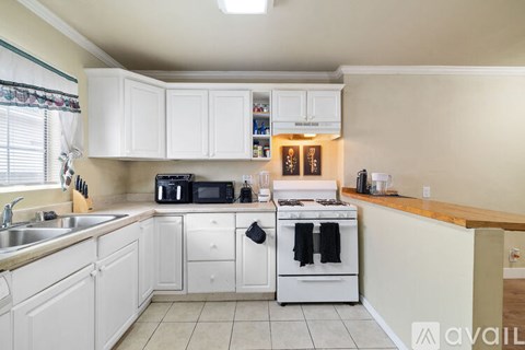 A kitchen with white cabinets and appliances.