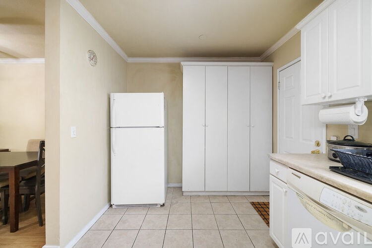 A kitchen with white appliances and cabinets.