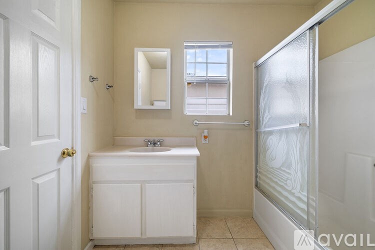 A bathroom with a white sink and a window.