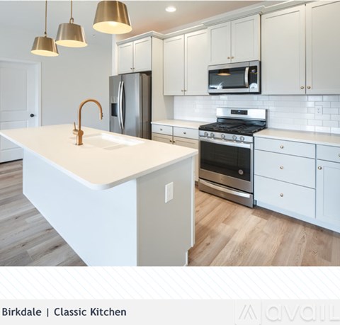 A modern kitchen with white cabinets and a white island.