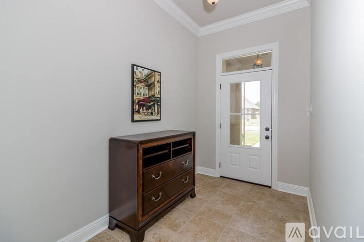 A brown dresser with a framed picture on the wall.