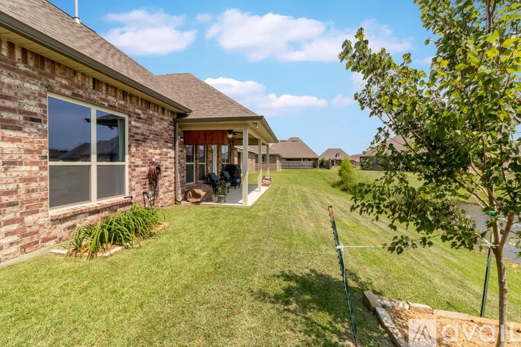 A house with a lawn and a tree in front of it.