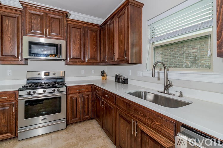 A kitchen with wooden cabinets and a stainless steel oven.