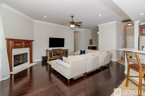 A living room with a white couch and a fireplace.