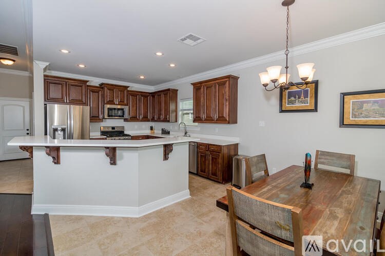 A kitchen with wooden cabinets and a white island.