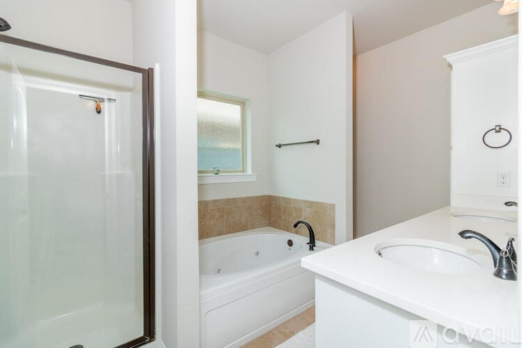 A white bathroom with a tub, sink, and mirror.