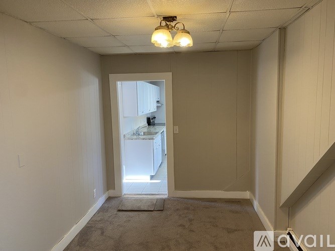 A room with a carpeted floor and a doorway leading to another room.