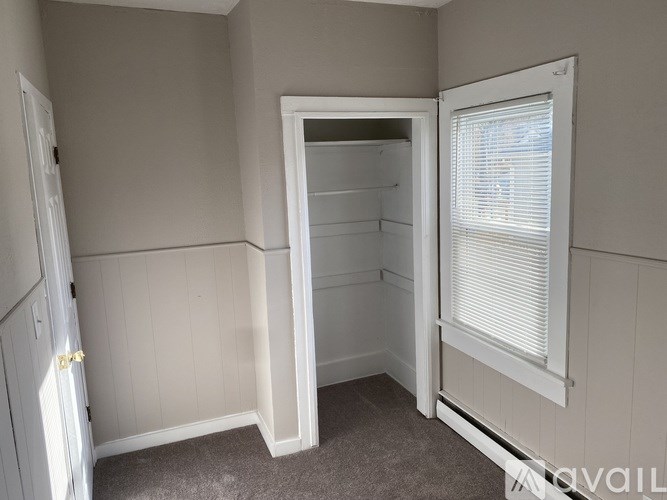 A small, empty room with a doorway leading to another room.