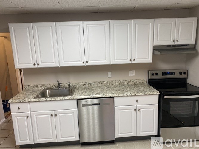 A kitchen with white cabinets and granite countertops.