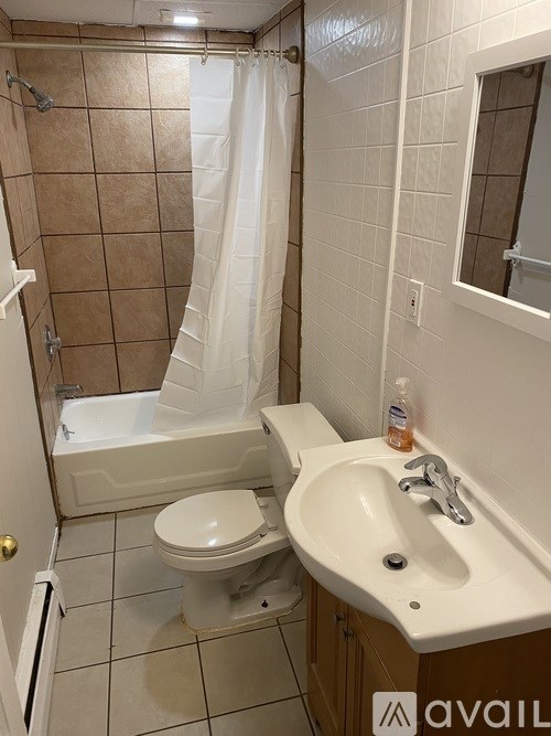 A bathroom with a toilet, sink, and shower.