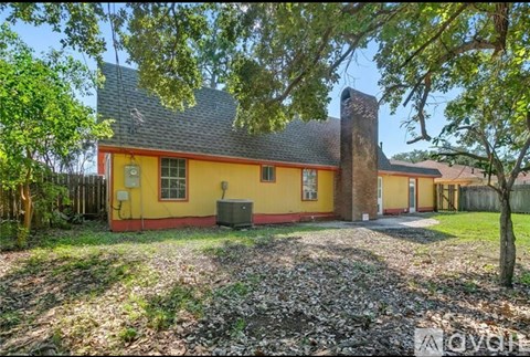 A yellow house with a red trim and a brown roof.