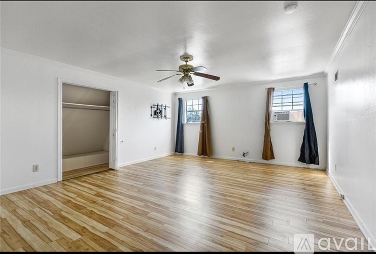 A room with wooden flooring and a ceiling fan.