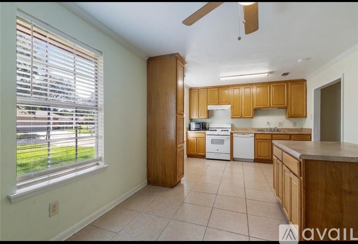 A kitchen with wooden cabinets and a white dishwasher.
