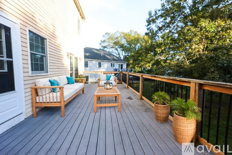 A wooden deck with a sofa and a coffee table.