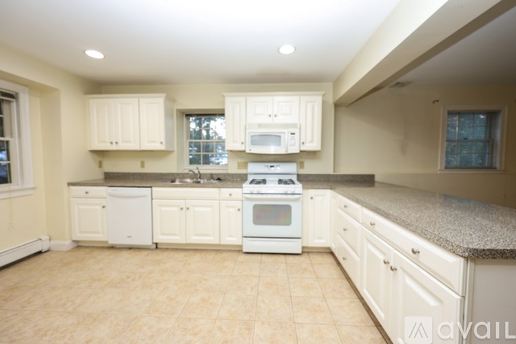 A kitchen with white appliances and cabinets.