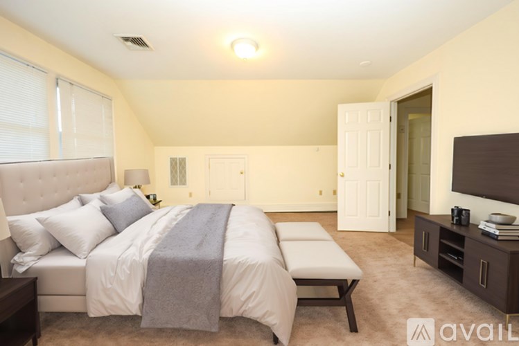 A bedroom with a large bed and a flat screen TV.