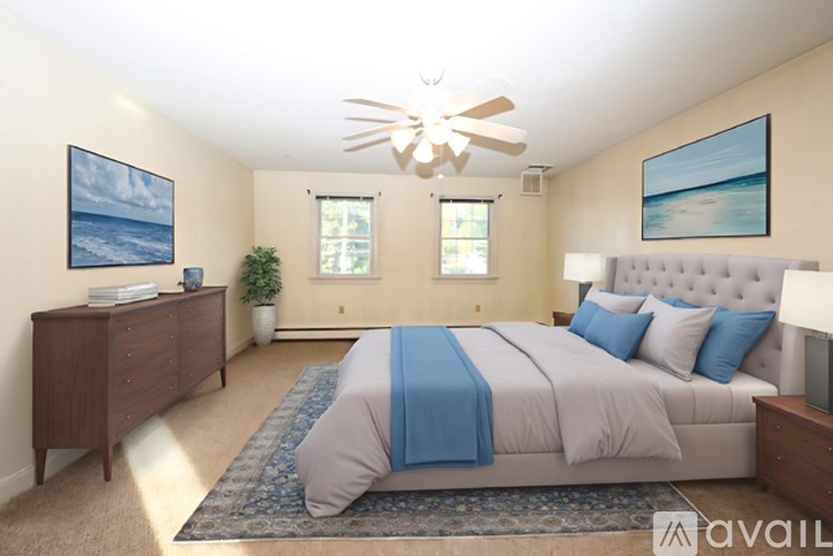 A bedroom with a large bed and a ceiling fan.