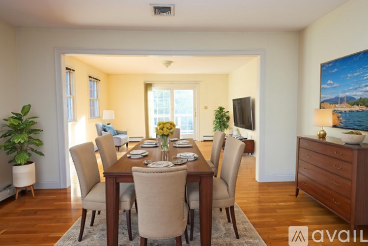 A dining room with a wooden table and chairs.