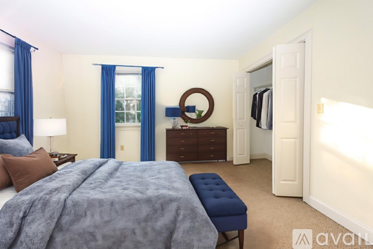 A bedroom with a large bed and a bench in front of it.