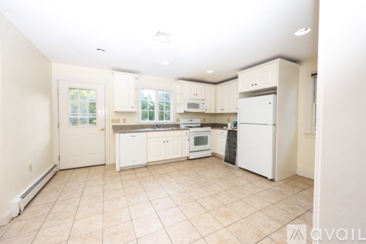 A kitchen with white appliances and cabinets.