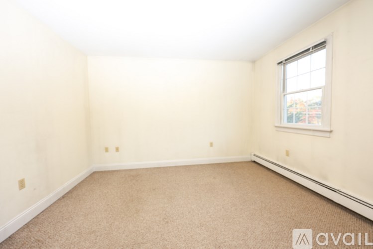 A room with a carpeted floor and a window.