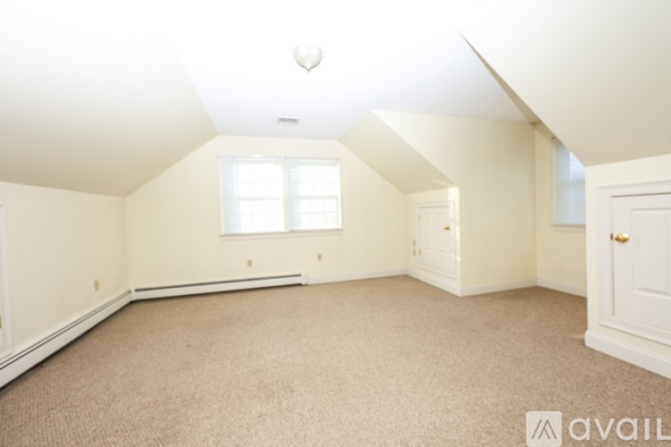 A room with a carpeted floor and a window.