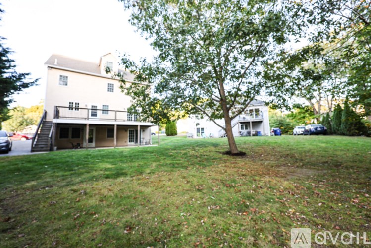 A white house with a tree in front of it.