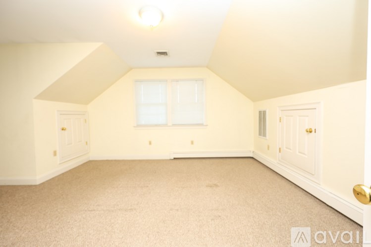 A room with a carpeted floor and a window.