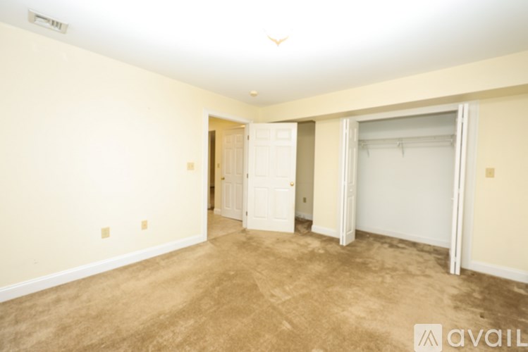 A room with a carpeted floor and a door leading to another room.
