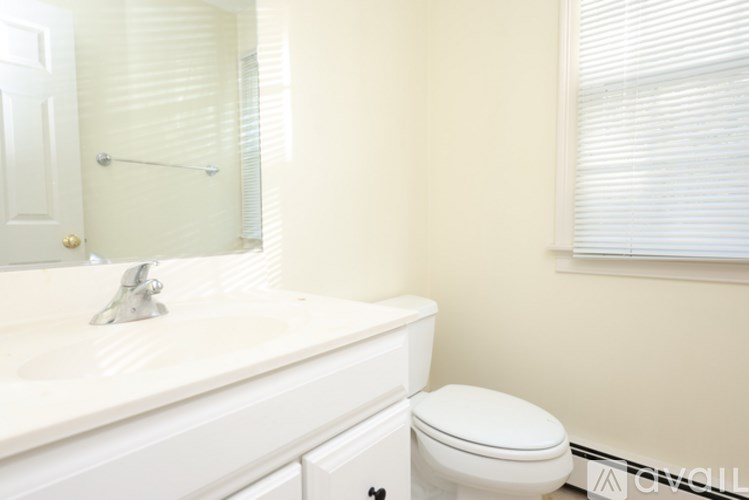 A white toilet sits next to a white sink in a bathroom.
