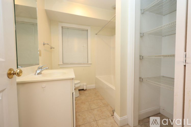 A bathroom with a sink, mirror, and a refrigerator.