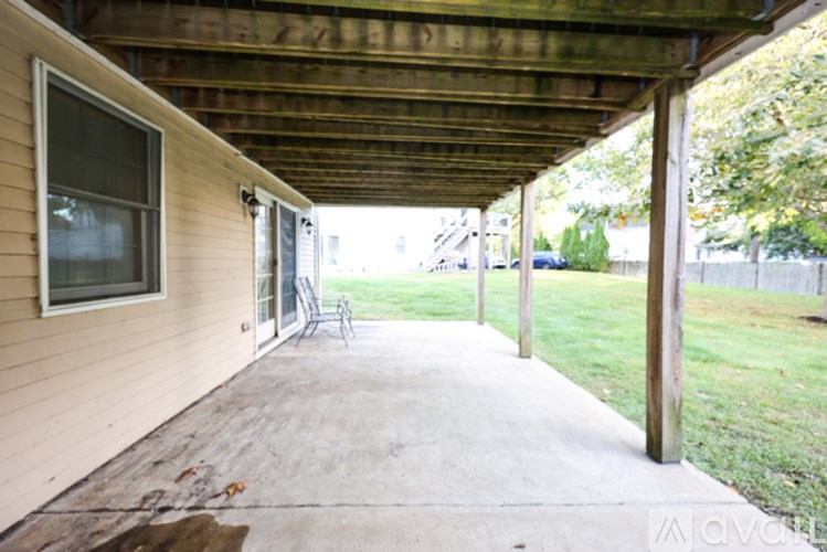 A patio with a sliding glass door and a wooden ceiling.