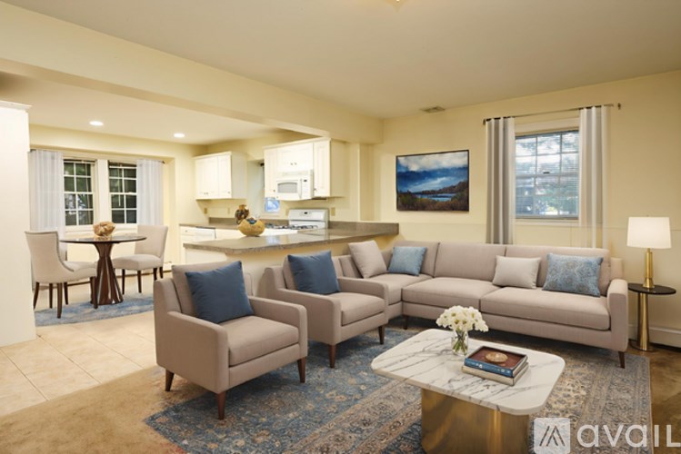A living room with a sofa set, a coffee table, and a painting on the wall.