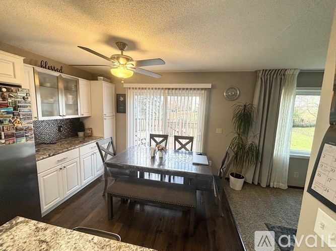 A kitchen with a table and chairs in front of a window.