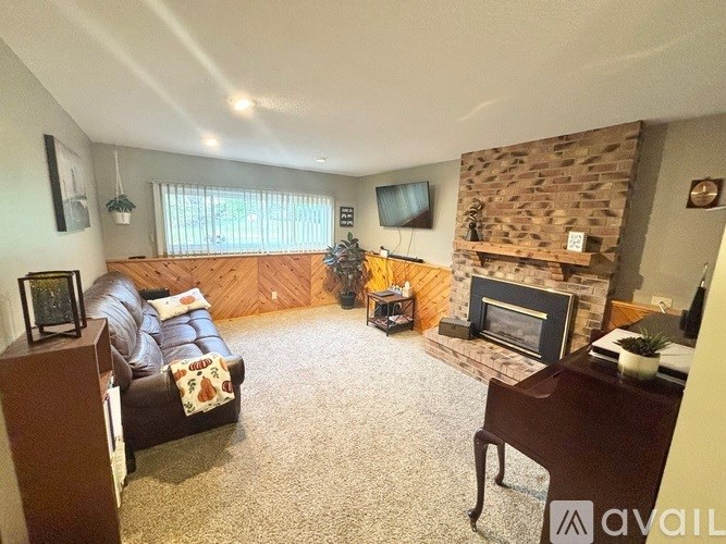 A living room with a brown couch and a fireplace.