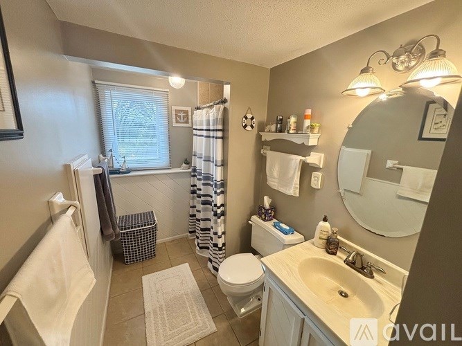 A bathroom with a toilet, sink, and shower area.