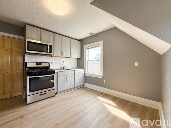 A kitchen with wooden cabinets and a stainless steel oven.