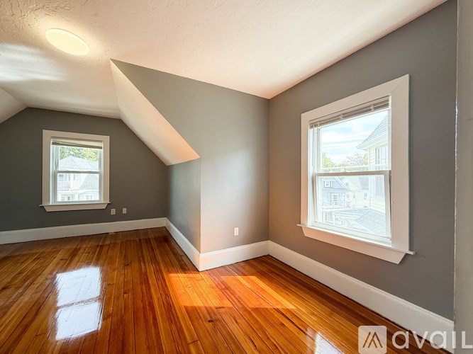 A room with wooden floors and two windows.