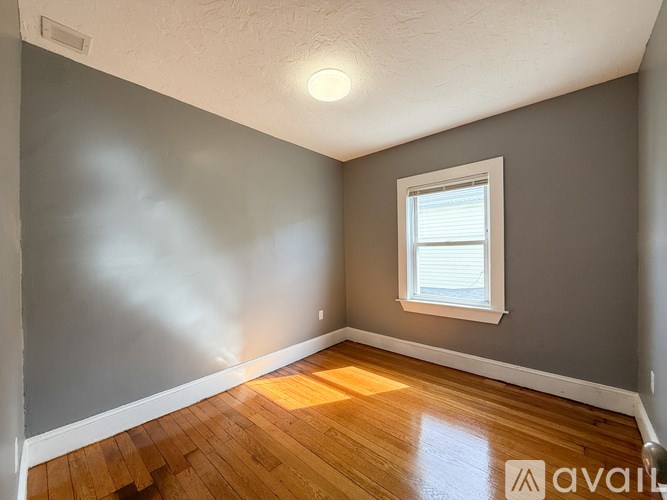 A room with a window and wooden flooring.