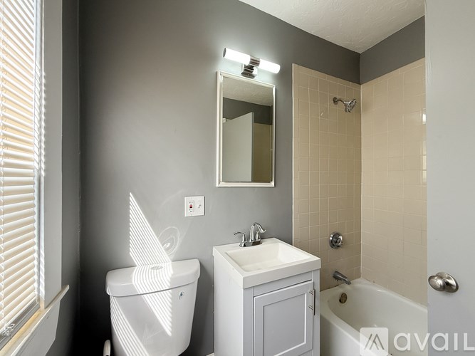 A white toilet sits next to a sink in a bathroom.
