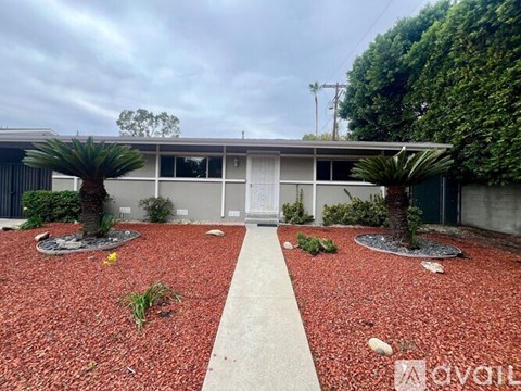 A building with a red gravel area in front of it.