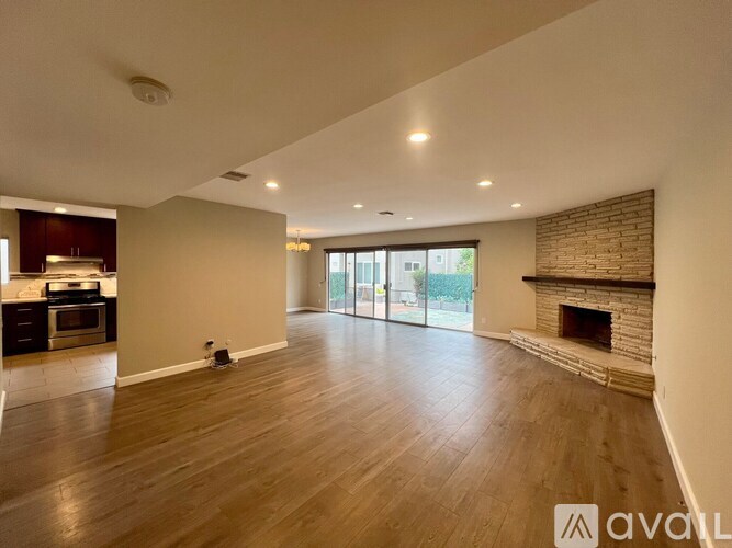 A spacious living room with a fireplace and sliding glass doors.