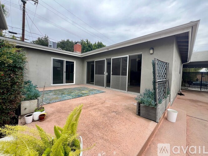 A house with a grey exterior and a patio area with a table and chairs.