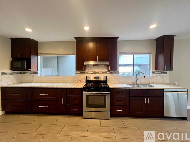A kitchen with brown cabinets and a white fridge.