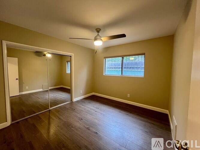 A room with a ceiling fan and a large mirror.